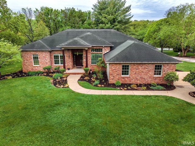 ranch-style house with roof with shingles, a front lawn, and brick siding