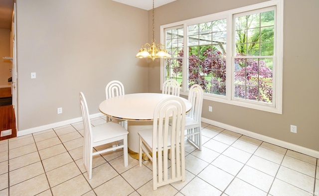 dining area featuring baseboards, a notable chandelier, and light tile patterned floors