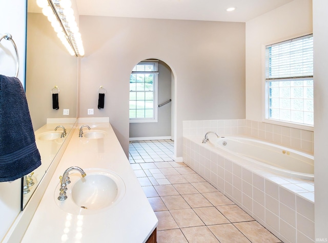 full bath with double vanity, tile patterned flooring, and a sink