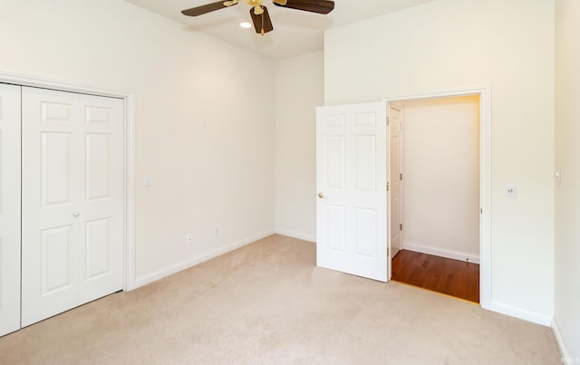unfurnished bedroom featuring carpet, baseboards, a ceiling fan, and a closet