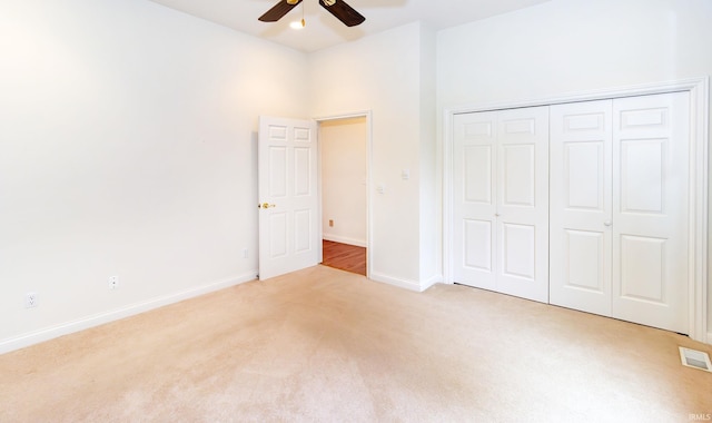 unfurnished bedroom featuring carpet, baseboards, a closet, and visible vents