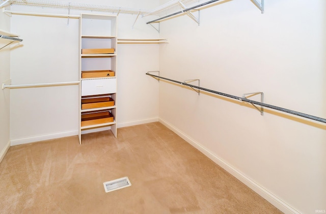 walk in closet featuring light colored carpet and visible vents