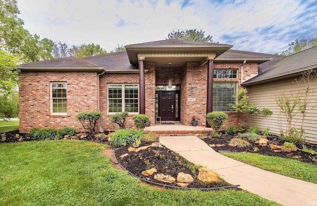 view of front of property with a front lawn and brick siding