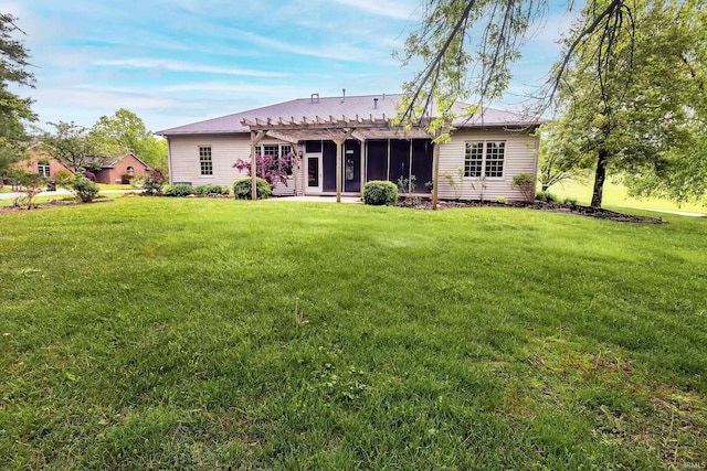 back of property with a sunroom, a pergola, and a lawn