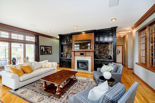 4052 Diamond Row, Greenwood, IN 46143 - living room featuring baseboards, a fireplace with flush hearth, light wood-style flooring, and crown molding