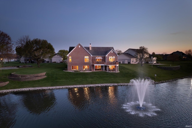 4052 Diamond Row, Greenwood, IN 46143 - back of property at dusk featuring a water view, a yard, a chimney, and a balcony
