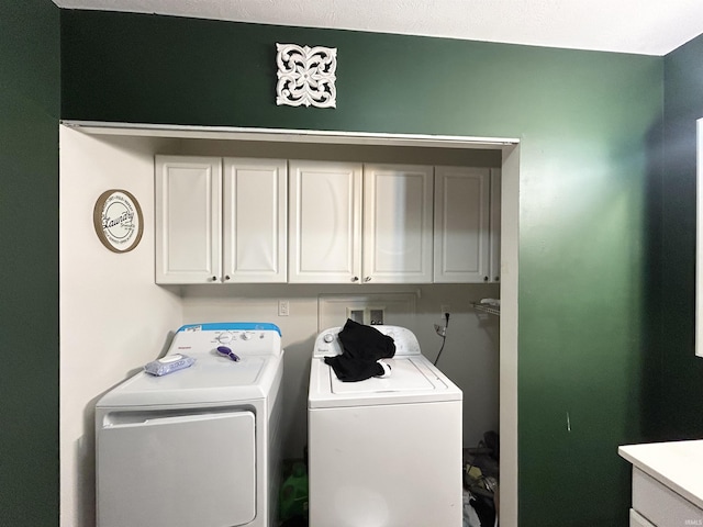 laundry area featuring washing machine and clothes dryer and cabinet space