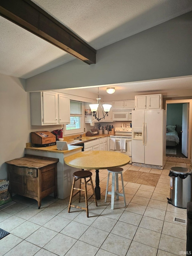 kitchen with a notable chandelier, a textured ceiling, white appliances, light tile patterned flooring, and white cabinetry