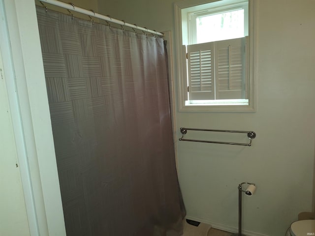 full bath with toilet and a shower with curtain