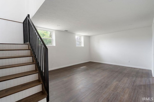 staircase with baseboards, visible vents, and wood finished floors