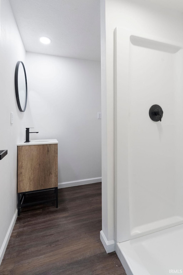 corridor with a sink, recessed lighting, baseboards, and wood finished floors