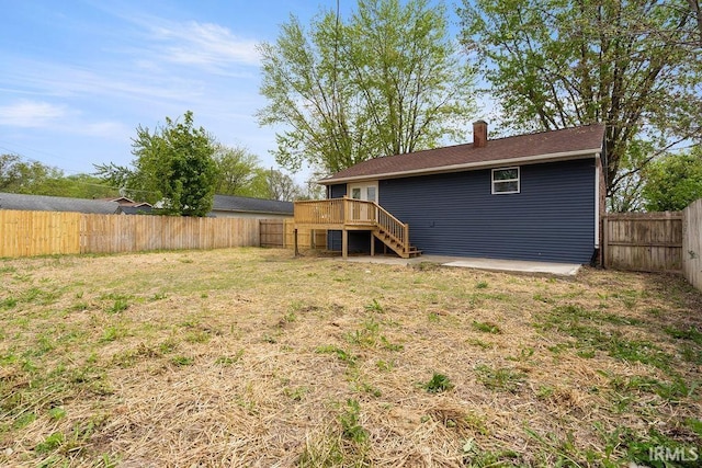 view of yard with stairway, a wooden deck, and a fenced backyard