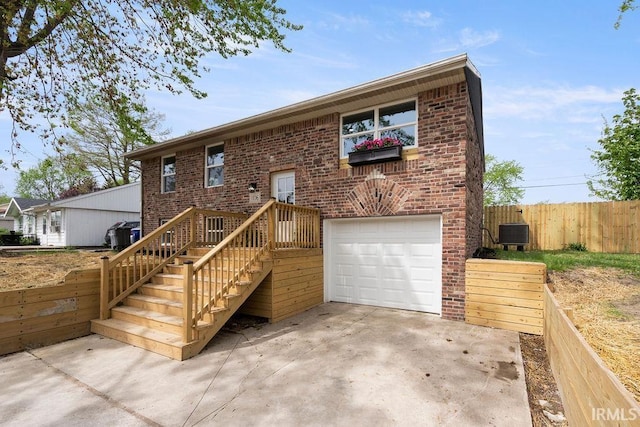 view of front of property featuring concrete driveway, brick siding, an attached garage, and fence