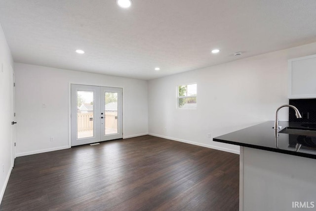 unfurnished dining area with french doors, recessed lighting, baseboards, dark wood-style flooring, and a sink