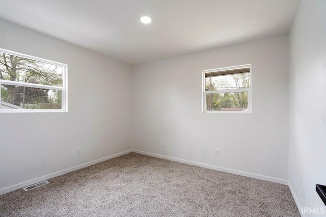 unfurnished room with carpet flooring, baseboards, visible vents, and recessed lighting