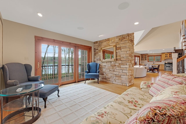 living area with a water view, light wood-style flooring, and recessed lighting