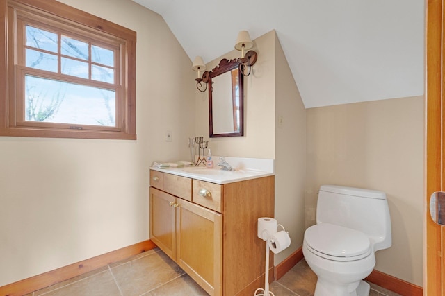 half bathroom with toilet, baseboards, tile patterned flooring, vaulted ceiling, and vanity