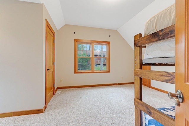 unfurnished bedroom with baseboards, carpet floors, and vaulted ceiling