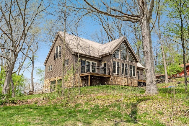 rear view of house with stone siding and a deck