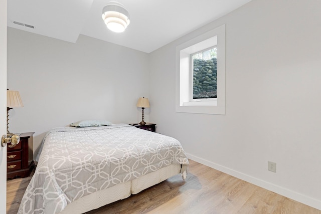 bedroom featuring baseboards, visible vents, and light wood-type flooring
