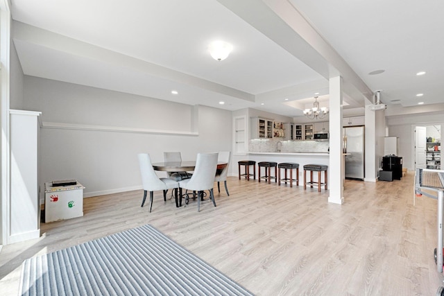 dining room featuring recessed lighting, a notable chandelier, baseboards, and light wood-style floors