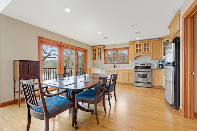 dining space featuring baseboards, light wood finished floors, and recessed lighting