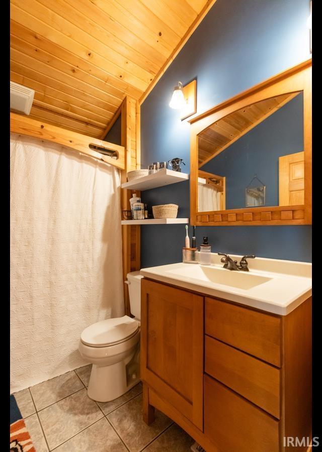 6705 S Shields Ridge Rd, Bloomington, IN 47401 - bathroom with toilet, vanity, tile patterned floors, vaulted ceiling, and wooden ceiling