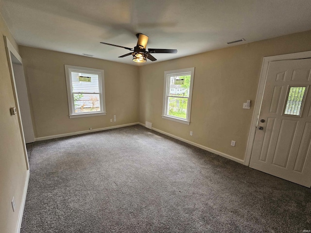 empty room with a wealth of natural light, carpet, a ceiling fan, and visible vents