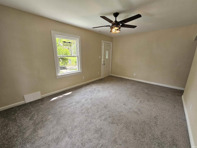 empty room with baseboards, ceiling fan, visible vents, and carpet floors