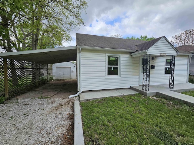 ranch-style house with fence, dirt driveway, an outdoor structure, a front yard, and roof with shingles