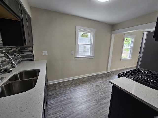 kitchen with freestanding refrigerator, plenty of natural light, tasteful backsplash, and a sink