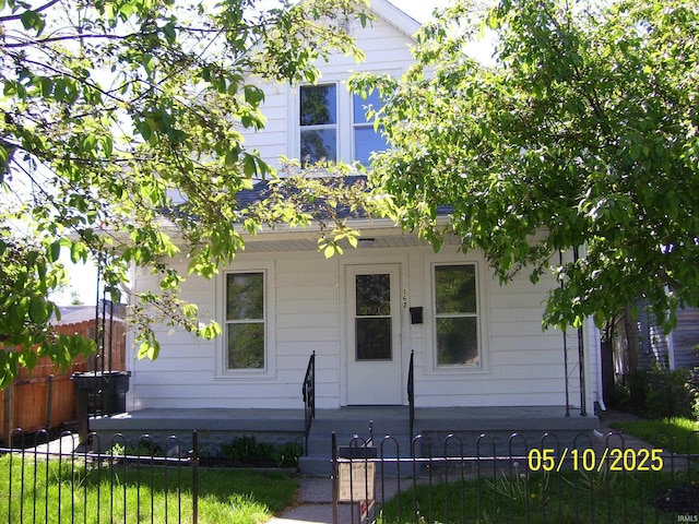 obstructed view of property featuring a porch and a fenced front yard