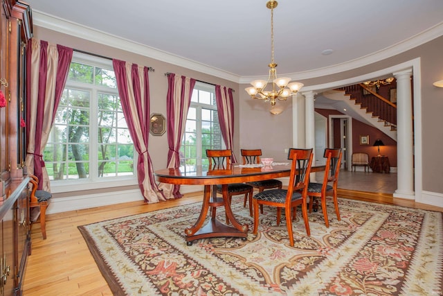 13 Rolling Ridge Ct, Jasper, IN 47546 - dining area featuring an inviting chandelier, light wood-style flooring, a healthy amount of sunlight, and decorative columns