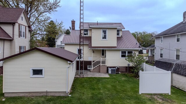 306 S Main St, Topeka, IN 46571 - rear view of house featuring a chimney, metal roof, fence, and a lawn