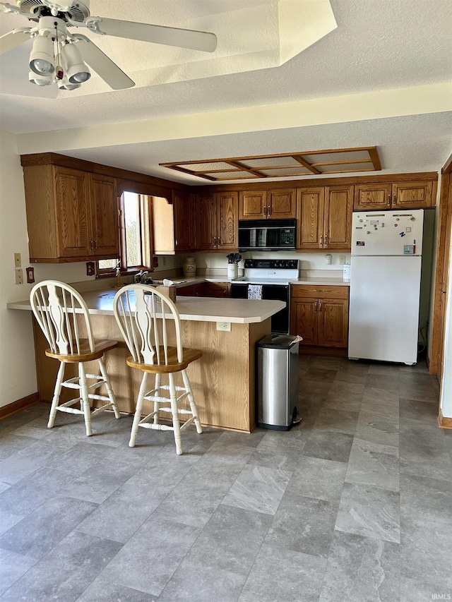2034 County Road 68, Auburn, IN 46706 - kitchen featuring freestanding refrigerator, range with electric cooktop, black microwave, a breakfast bar area, and a peninsula