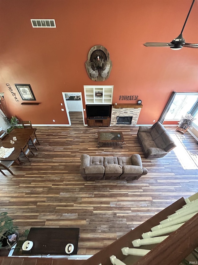 2034 County Road 68, Auburn, IN 46706 - living room with a towering ceiling, wood finished floors, a fireplace, ceiling fan, and baseboards