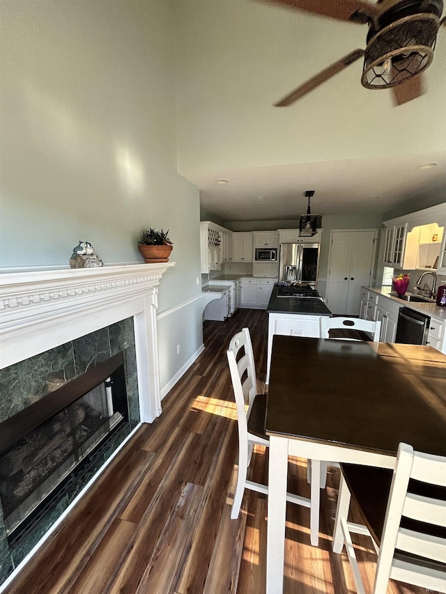 2034 County Road 68, Auburn, IN 46706 - dining room featuring dark wood-type flooring, a premium fireplace, ceiling fan, and baseboards