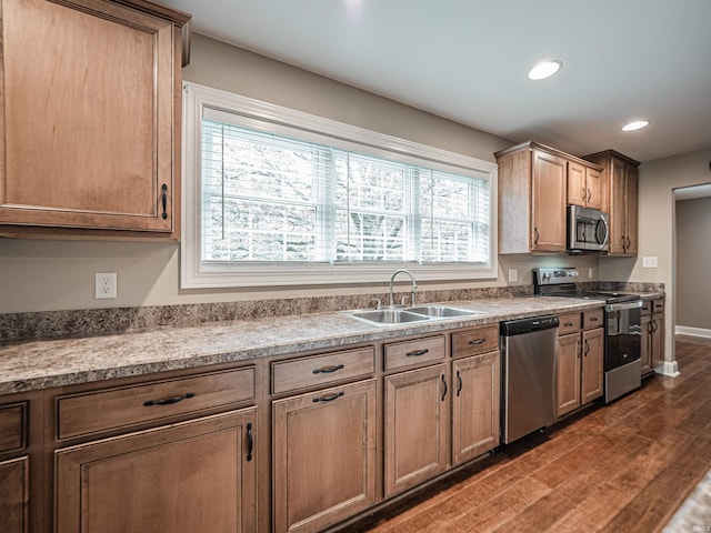 kitchen with a sink, dark wood-type flooring, recessed lighting, baseboards, and appliances with stainless steel finishes