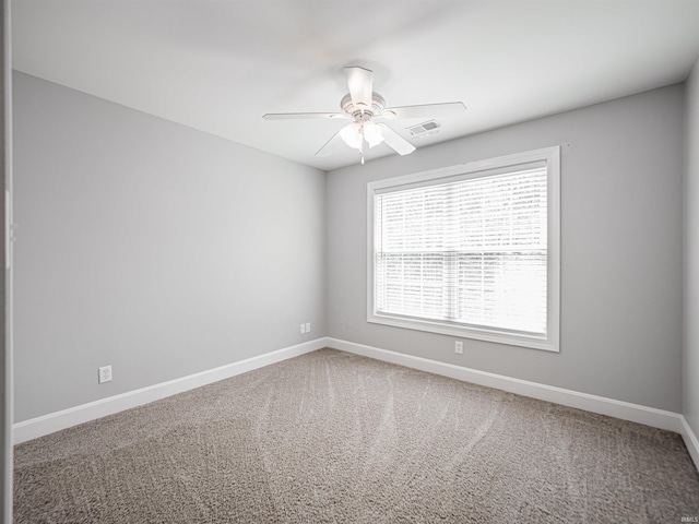 spare room with visible vents, baseboards, ceiling fan, and carpet floors