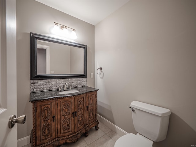 bathroom with toilet, baseboards, tile patterned floors, vanity, and decorative backsplash
