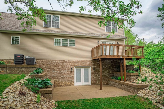 rear view of property with central air condition unit, a patio area, a wooden deck, and brick siding