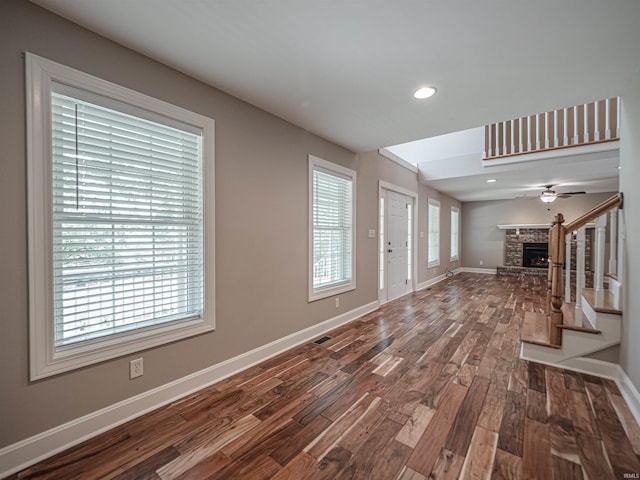 foyer with a lit fireplace, dark wood-style flooring, baseboards, and recessed lighting