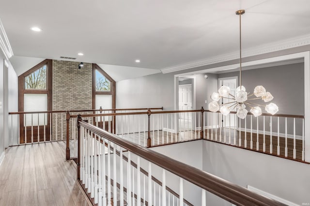 hall with crown molding, a notable chandelier, an upstairs landing, and visible vents