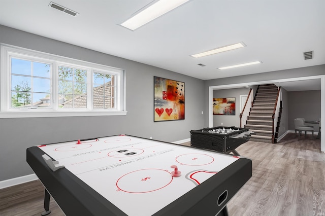 recreation room with wood finished floors, visible vents, and baseboards