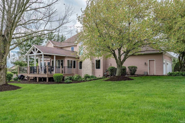 rear view of house featuring a lawn, a deck, roof with shingles, and a garage