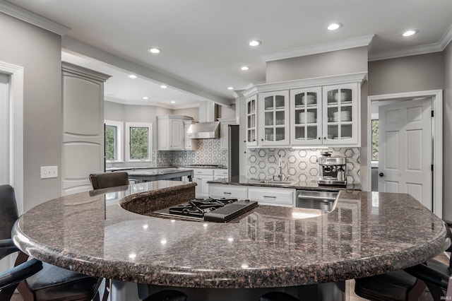 kitchen with stovetop with downdraft, a spacious island, decorative backsplash, and a kitchen bar