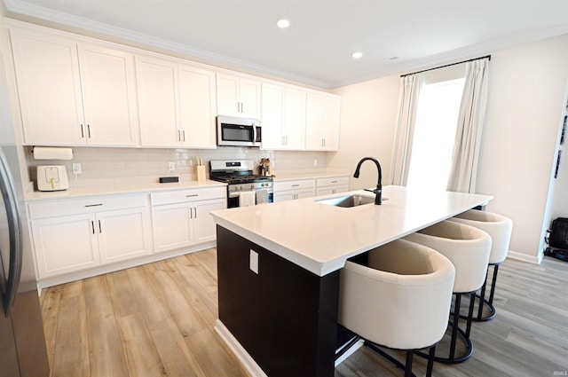 6357 Spirea Ct, West Lafayette, IN 47906 - kitchen with stainless steel appliances, light wood-style flooring, a kitchen bar, and a sink