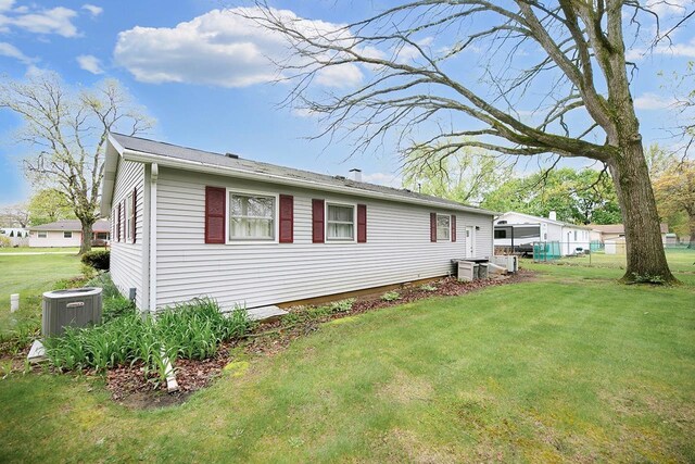 view of side of property with a lawn and fence