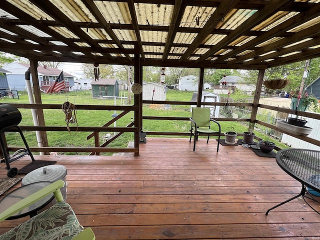 wooden deck featuring a storage shed, a yard, an outdoor structure, and a residential view