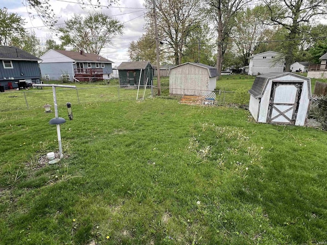 view of yard featuring fence, an outdoor structure, and a shed